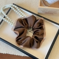 Détail d'un chouchou en satin marron café avec bordure en mesh pailleté de style rétro - Café Dentelle Maille