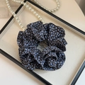 Dettaglio di un elastico in chiffon floreale con collana di perle su vassoio - Doppio Strato Blu Floreale