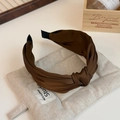 Detail view of a knotted brown satin headband on a premium textured display surface - Dark Coffee