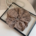 Dettaglio dell'elastico per capelli leopardato su un vassoio con perle decorative - 19cm / Leopardo Chiaro