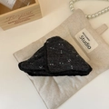 Detalle de pinza para pelo gris con flores y encaje negro sobre una bolsa de lino - Negro
