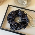 Dettaglio di un elastico in raso a pois neri su un vassoio vintage con perle lucide - Nero Doppio Strato Pois