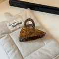 Vue détaillée de la pince à cheveux triangle en écaille avec la lettre B en métal doré - Marron