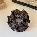 Detail van vintage blauwe bloemen scrunchie met gelaagde randen op witte achtergrond - Donkerbruine Bloemenstijl