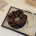 Dettaglio di elastico per capelli leopardato con bordo in pelle nera e trama a pieghe - Stile Patchwork Stampa Leopardata e Pelle Nera