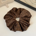 Dettaglio di un elastico in raso leopardato con perle per un look retrò raffinato - Stile Tutto Stampa Leopardata