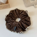 Dettaglio di elastico leopardato con bordo di perle bianche ed etichetta nera in tessuto - Stile Mandorla Leopardo Perla
