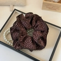 Detailed view of brown floral scrunchie with layered pleats on a vintage tray - Brown