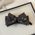 Detail of grey wool bow hair clip with white polka dots and gold heart ornament - Gray