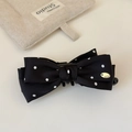 Dettaglio della clip a banana con fiocco in chiffon a pois e placca in metallo oro - Fermaglio a banana a fiocco