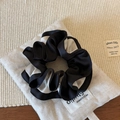 Détail d'un chouchou en satin bicolore avec texture plissée sur un sac en coton - Style Patchwork Noir