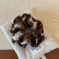 Vue détaillée d'un chouchou bicolore en satin marron et crème sur fond neutre - Café & Beige Patchwork