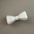 Detailed close-up of a pearly cream bow hair clip with scalloped hollowed edges - White Pink