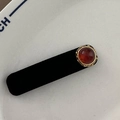 Detailansicht einer schwarzen Samt-Haarspange mit rotem Edelstein in Goldfassung - Bernstein Rechteckig BB-Rundes Rotbraun