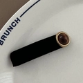 Detail einer Samthaarklammer mit goldenem Bernsteindekor auf einem Keramikteller - Bernstein Rechteckig BB-Rundes Katzenauge