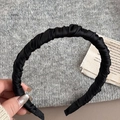 Vista detallada de la diadema de satén plisado negro con textura de tela y diseño fruncido - Negro