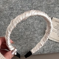 Detalle de la diadema de satén plisado champán con textura suave y puntas protectoras - Blanco