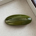 Close-up of dark green oval acetate hair clip with gold France Handmade lettering - Green