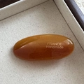 Detail showing amber acetate oval hair clip with France Handmade text on fabric - Brown