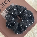 Detailansicht eines schwarzen gepunkteten Haargummis aus strukturiertem Bouclé-Stoff - Scrunchie / Schwarz