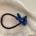 Detalle de un coletero de conejo azul marino sobre una bandeja de cerámica blanca - Azul Klein