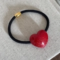 Dettaglio di elastico per capelli nero con ciondolo a cuore rosso glitterato e perla dorata - Cuore
