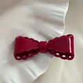 Détail d'un nœud papillon bordeaux avec motif dentelle sur un support en forme de coquillage - Rouge Nouvel An - Grand Nœud Ajouré