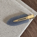Détail d'une pince à cheveux mate bleue pailletée avec base dorée sur tissu naturel - Bleu Pailleté