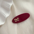 Détail d'une pince à cheveux ovale rouge foncé avec nœud doré sur tissu de soie - Rouge Nouvel An - Oval Nœud Doré