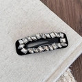 Vue détaillée de la pince à cheveux noire avec des strass étincelants de formes variées - Strass Irrégulier BB-Rectangle