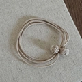Dettaglio dell'elastico per capelli beige con nodi a bottone su tela testurizzata - Beige