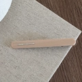 Detail of matte beige hair clip with gold France Handmade lettering on linen texture - Beige