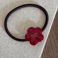 Nahaufnahme von hochelastischem Haargummi mit rotem Acetat-Blütenanhänger auf Leinen - Acetat Blume Haargummi (FQ88971) / Rot