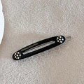 Close-up of black oval hair clip with colorful rhinestones and gold Creation France logo - Black