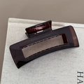 Dettaglio di una pinza per capelli marrone scuro traslucida con finitura lucida su lino - Stile Rettangolo Grande / Tè Trasparente