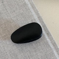 Detailed view of a black matte metal teardrop hair clip on a textured fabric surface - Black