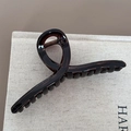 Detail of a dark brown translucent shark hair clip with a glossy finish and spiral design - Hanger Shape Style / Transparent Tea