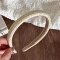 Close-up of beige woven straw headband showing natural texture and anti-slip lining - Off White