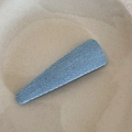 Vista detallada de una pinza triangular con textura de mezclilla sobre plato de cerámica - Azul Claro - Gota de Agua