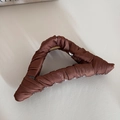 Detail of elegant dark brown pleated satin fabric wrapped on a large metal shark hair claw - Coffee Triangle Pattern