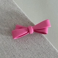 Detailed macro view of pink resin bow hair clip with polished finish and smooth surface - Candy Knot Duckbill / Pink