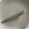 Dettaglio macro del fermaglio per capelli in acrilico verde opaco con base oro rosa - Verde Grigio