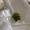 Gros plan d'une mini pince à cheveux en forme d'ours vert olive en acétate poli - Vert