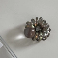 Dettaglio dell'elastico per capelli a spirale grigio con una perla decorativa in resina - Marrone