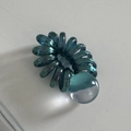 Dettaglio di elastico a spirale verde acqua metallizzato con ciondolo a sfera sfumato - Verde