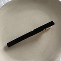 Dettaglio di un fermaglio per capelli in acrilico nero con base in metallo dorato in vassoio - Nero