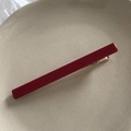 Dettaglio di un fermaglio per capelli in velluto rosso scuro con base in metallo dorato - Borgogna