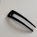 Close-up of sleek black U-shaped hair pin with rhinestone detail and handmade lettering - Black