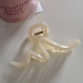Detail view of a large cream wavy hair claw clip with a strong golden metal spring - Line-Jelly White