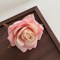Close-up of pink fabric misty rose flower clip with layered petals and green leaves decoration - Pink White Gradient